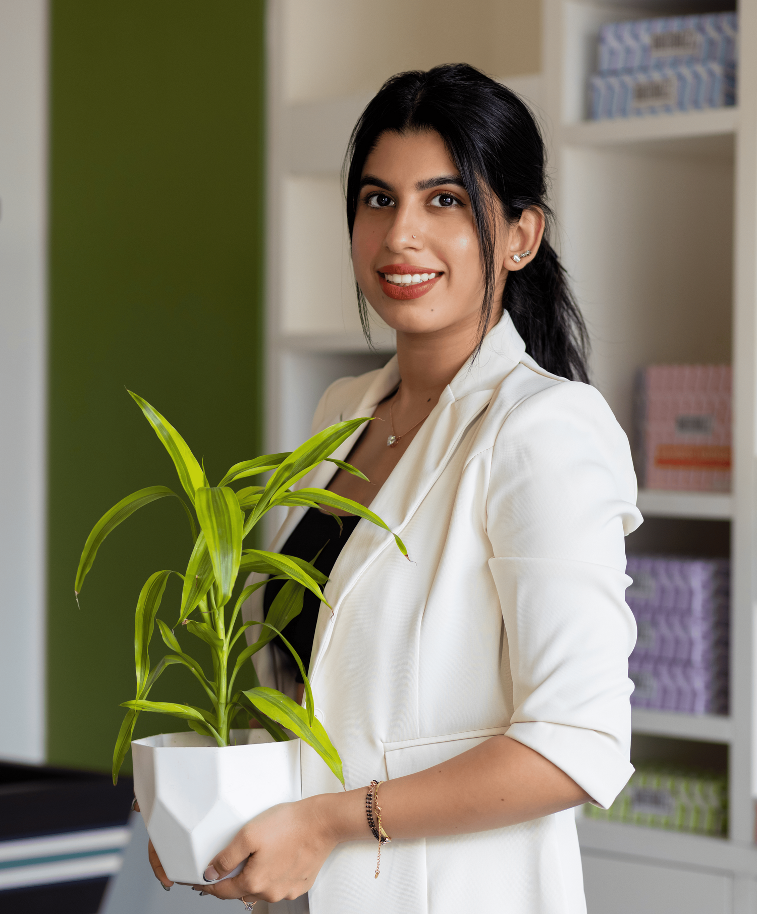 kashish grover the founder of Bammbuzz a bamboo tissue brand holding a potted plant in an indoor setting